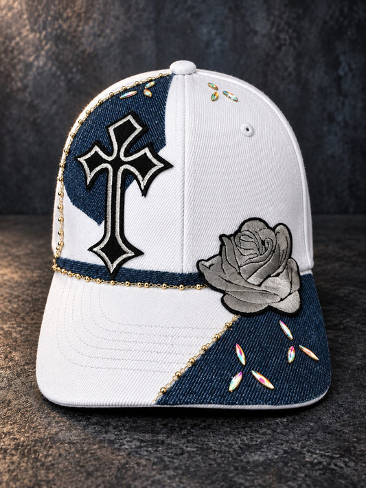 White and denim statement cap with black and white cross, gray rose, gold chain, and iridescent rhinestone accents