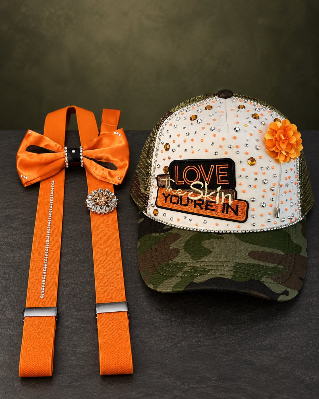 Love the Skin You're In camo embellished cap with orange suspenders and bow tie