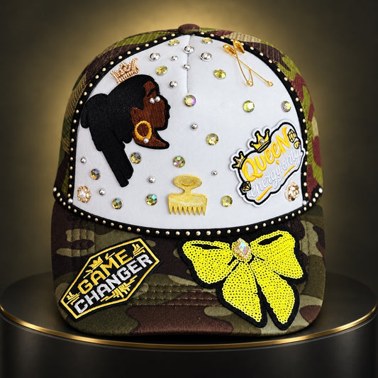 Camo and white Queen Energy statement cap with yellow bow, rhinestones, gold accents, and Black woman silhouette