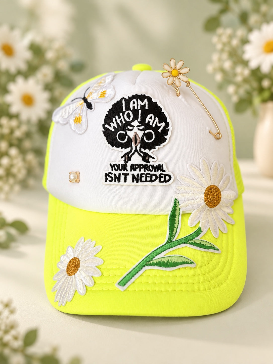 White and neon yellow statement cap with I Am Who I Am Your Approval Isn't Needed patch, daisy appliques, bee detail, pearl accent, and decorative pin