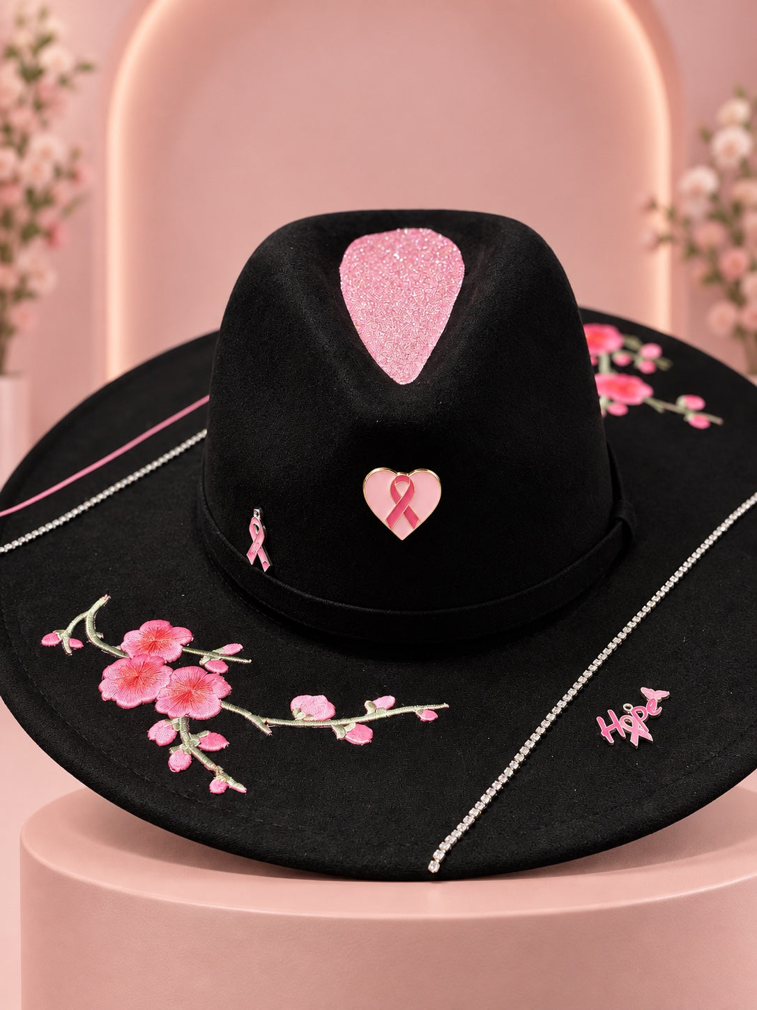 Black wide-brim Breast Cancer Awareness fedora with pink floral embroidery, rhinestone trim, ribbon pins, and Hope charm