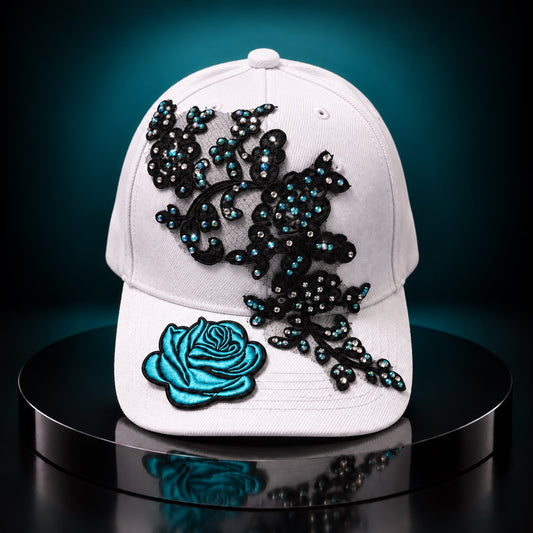 White statement cap with black lace applique, turquoise rhinestones, and turquoise rose